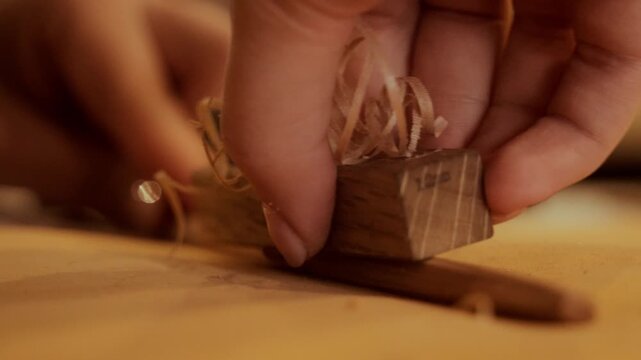 Artisan hands carefully shaving a wooden surface with a small hand plane