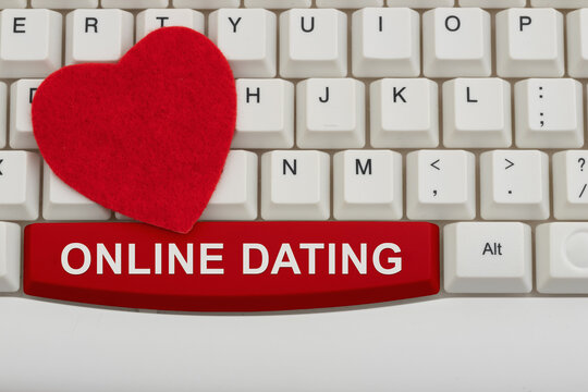 Online Dating text with a red heart on a white computer keyboard for meeting on the internet