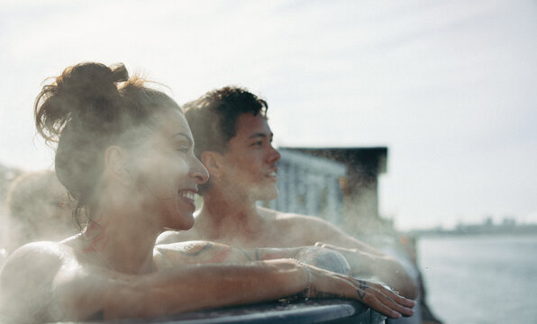 Friends enjoying spa wellness in outdoor hot tub with steam