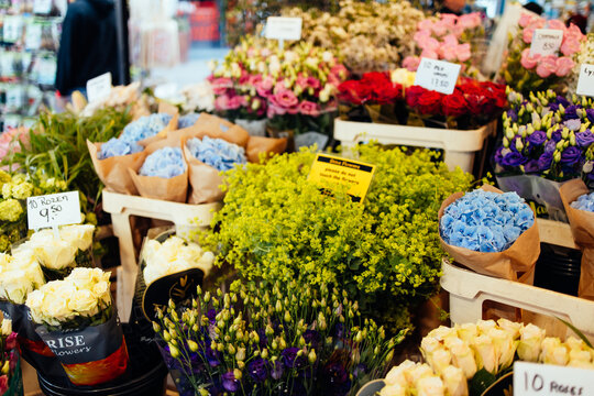 orizontal close-up shot of a vibrant flower stall counter at the Bloemenmarkt in Amsterdam, Netherlands. Bouquets 