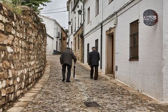 Two middle-aged men are walking up the street in &Uacute;beda, a World Heritage City in Spain