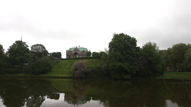 Scenic Wide-Angle View of the Glockenspielpavillon and Green Embankment Reflected in the Zwinger Moat Water