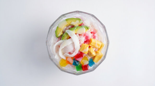 Top view of traditional Indonesian es oyen dessert with colorful fruits, jelly and shaved ice isolated on white background.