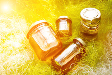 Fototapeta premium Honey in glass jars with flowers background.