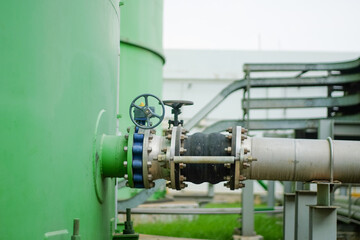 Obraz premium Industrial water pipe system with valve, green tank and pipes