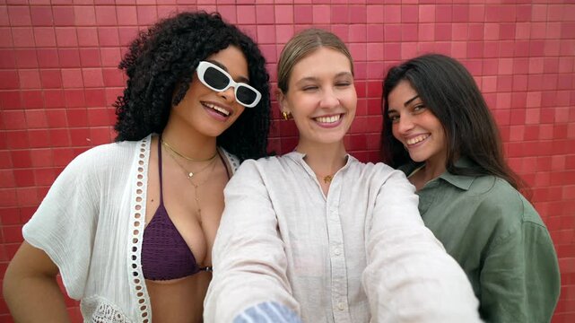 Three happy women friends taking selfie video