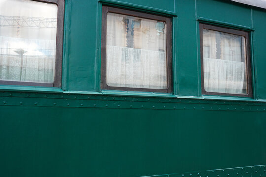 Green train windows reveal a glimpse of stories untold in daylight