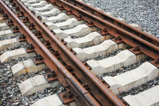 Rusty train tracks create a pattern of lines and textures in sunlight