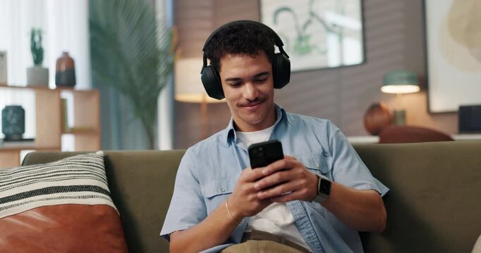 Headphones, phone and man on sofa in home for chatting, relaxing and listening to music. Audio tech, cellphone and male person with social networking and streaming album on mobile app in living room.