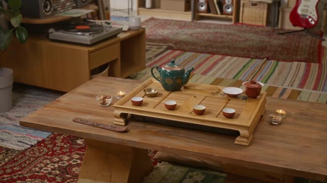 High angle no people shot of table with tea set, candles, and refreshments during traditional tea ceremony at home