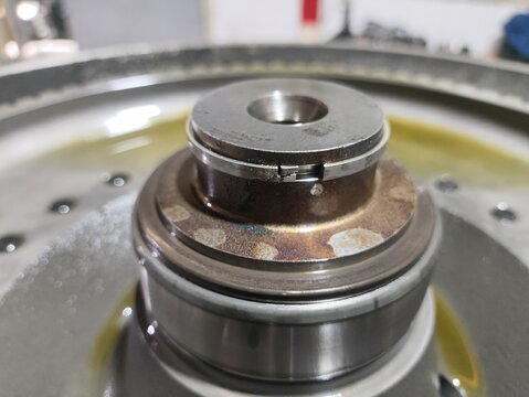 ​Close up macro view of an industrial metallic transmission shaft end fitted with a retaining snap ring or circlip.