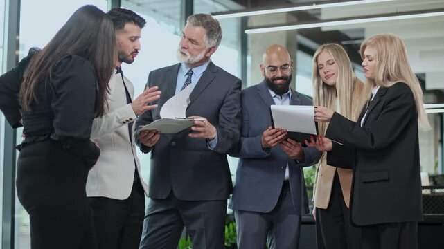 Five professionals gather in a modern office space