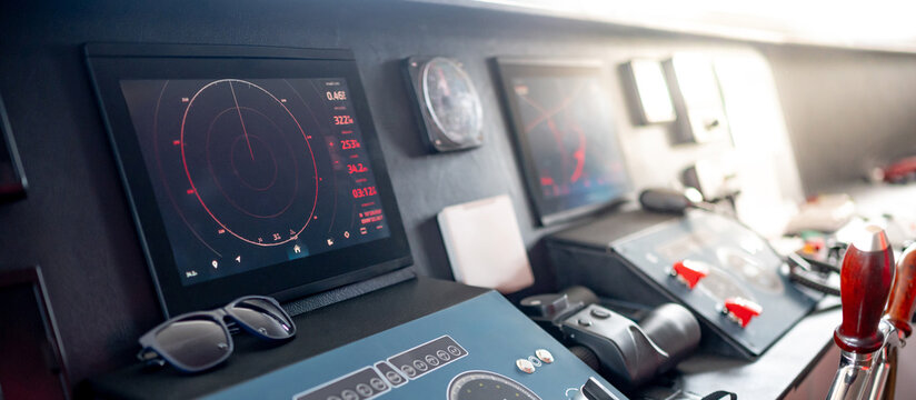 Digital dashboard with navigation monitor system, marine radar, VHF Radio and binoculars in ship captain bridge. Wheelhouse steering console on Nautical vessel transport. Modern boating technology