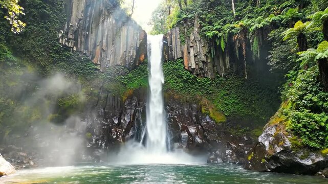 Tropical waterfall cascading down basalt columns in a lush jungle