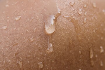 Fototapeta premium Scientific macro photography of water droplet surface tension on human skin texture