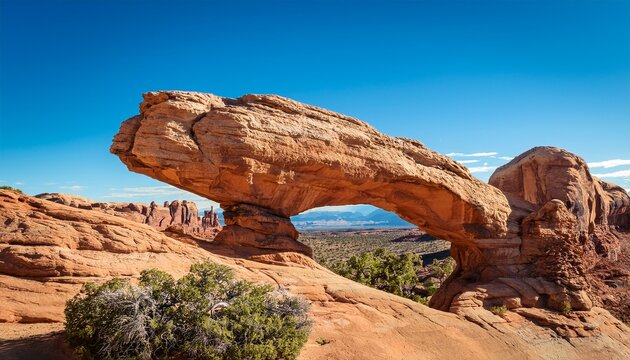Balanced Rock Formation In Desert Landscape With Blue Sky And Arid Vegetation Natural Arch