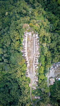 Aerial view of Bena Traditional Village with iconic thatched roof houses arranged in rows and surrounded by lush tropical forest, Kecamatan Jerebuu, Nusa Tenggara Timur, Indonesia.