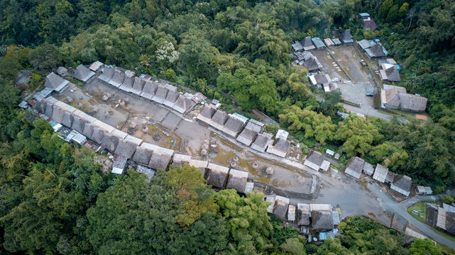 Aerial view of Bena Traditional Village featuring rows of thatched-roof houses nestled within dense tropical forest in Kecamatan Jerebuu, Nusa Tenggara Timur, Indonesia.