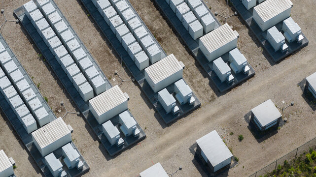 Aerial view of a large-scale battery energy storage system with rows of containerized units on a gravel surface in Wanneperveen, Overijssel, Netherlands.