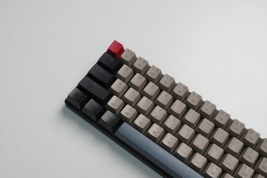 Close up high angle view of a custom mechanical keyboard with gray, black, and red keycaps