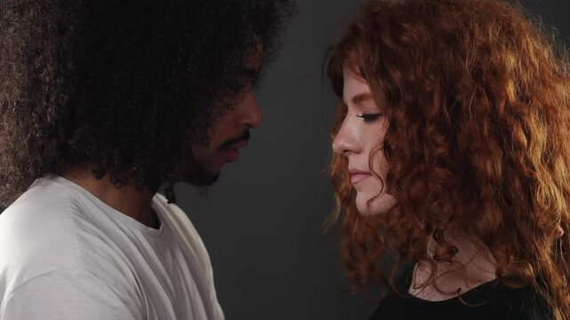 This depicts the dynamics of an interracial couple s relationship, showcasing a man and woman facing each other in profile. The woman initially looks at the man, then gently closes her eyes, conveying