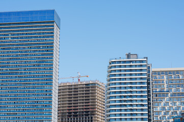 Obraz premium High-rise building under construction with tower crane, urban development and real estate concept