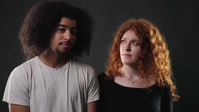 Relationship conflict and misunderstanding, a young couple looking away from each other, conveying tension and emotional distance. This footage is editorial content, documentaries, or commercial proje