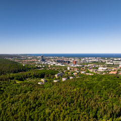Beautiful city landscape of Gdansk in Poland, taken from the hills of Niedzwiednik district. Green forest of Tri-city Landscape Park and the Baltic Sea bay visible on the horizon. © BlackMediaHouse