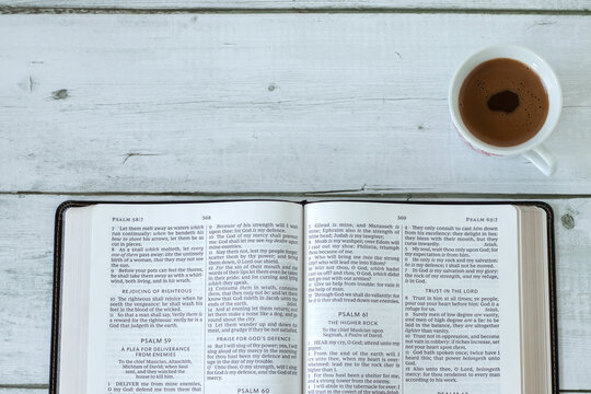 Christian holy bible book with coffee cup on wooden background. Top view. Copy space. Scripture study concept.