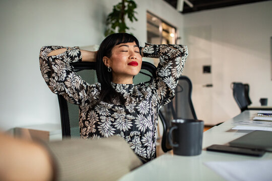 Businesswoman relaxing at office desk during break