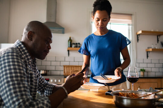 Couple eating pasta and drinking wine in home kitchen