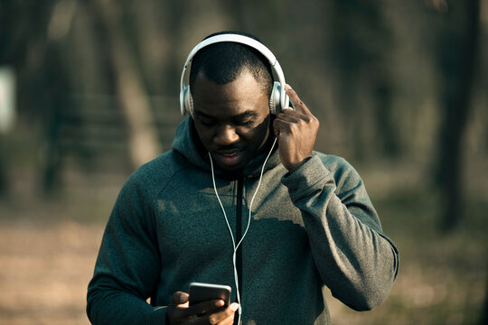Young man listening to music with headphones in park