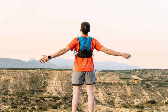 Trail runner enjoying freedom and success on mountain peak