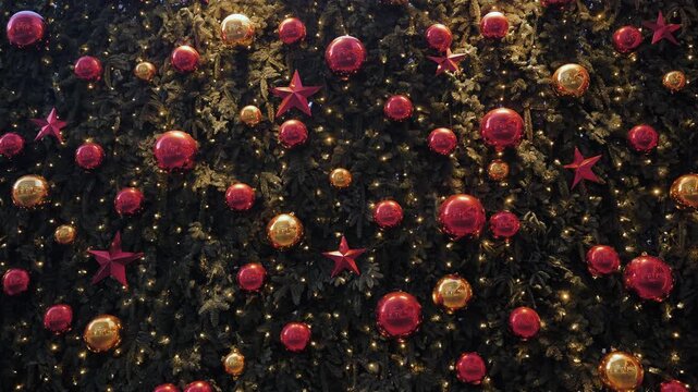 Christmas tree decorating with red and golden baubles, stars, and string lights