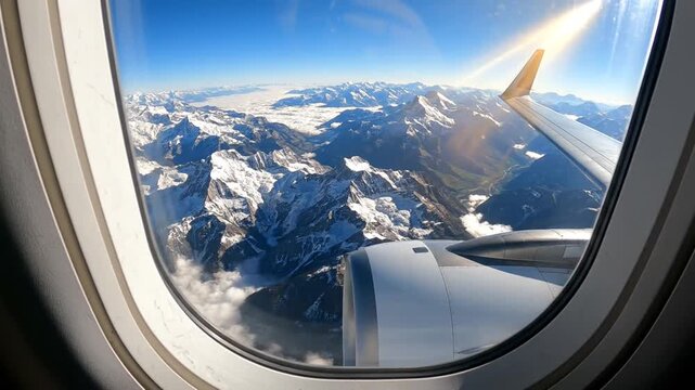 Stunning aerial view from airplane window showcasing snow-capped mountains and clear skies.