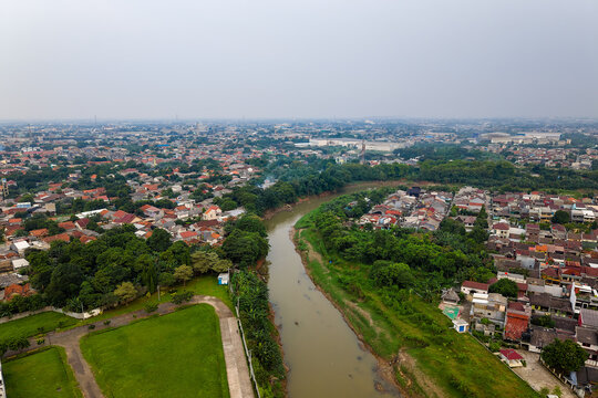 Showing air pollution over Jakarta cityscape near Kali Bekasi River, aerial view