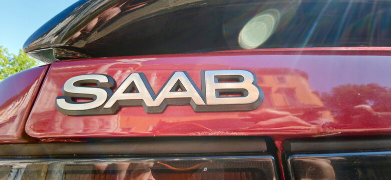 Saint Petersburg, Russia - May 23, 2026: Close-up view of a red Saab car emblem showcasing the brand name on the rear trunk, sunlight reflecting off the surface