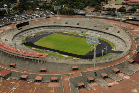 Aerial view of Estadio Olimpico Universitario showing the green pitch, running track, and concrete stands under daylight in Ciudad de Mexico, Ciudad de Mexico, Mexico.
