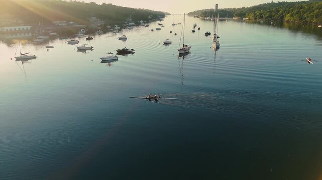 In the calm waters of Halifax Ocean Bay, a team of spirited young women skillfully navigates their two-seater rowing boat. They demonstrate teamwork and dedication under the warm sun