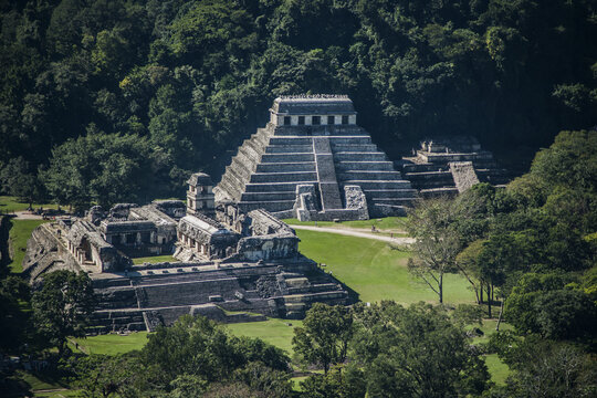Aerial view of the ancient Mayan ruins of Zona Arqueologica Palenque featuring the Temple of the Inscriptions and the Palace surrounded by dense jungle in Palenque, Chiapas, Mexico.