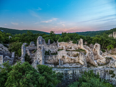 Aerial view of Dvigrad ruins featuring ancient stone walls surrounded by lush green forest and rolling hills under a soft twilight sky Kanfanar, Istria County, Croatia.
