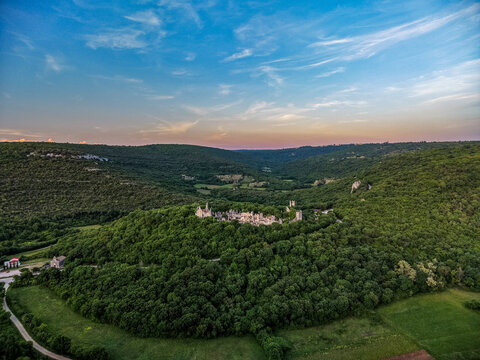 Aerial view of the medieval Dvigrad ruins on a forested hill surrounded by the lush Lim valley under a sunset sky Kanfanar, Istria County, Croatia.