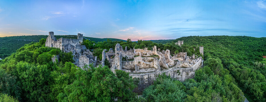 Aerial view of the medieval Dvigrad ruins featuring ancient stone walls and towers surrounded by lush green forest at twilight in Kanfanar, Istria County, Croatia.