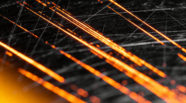 Abstract close-up of glowing orange and black scratched surface