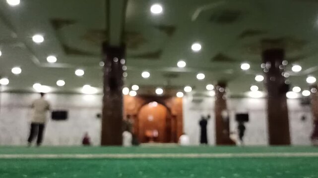 Artistic blur and defocus view inside a mosque during Maghrib prayer time, creating a peaceful spiritual atmosphere with soft evening lighting.