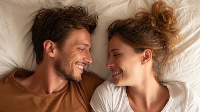 A happy couple in love communicate face-to-face while relaxing in bed.