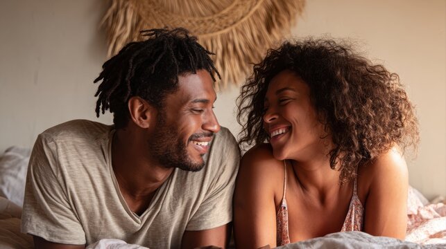 A happy couple in love communicate face-to-face while relaxing in bed.