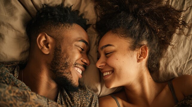 A happy couple in love communicate face-to-face while relaxing in bed.