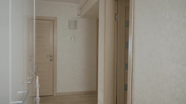 Woman remains uncertain before her apartment entrance. Girl pauses briefly just outside building entrance door. Young woman hesitates momentarily on threshold before entering her apartment