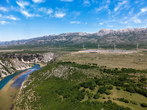 Aerial view of Suncana elektrana Obrovac solar power plant and wind turbines near the Zrmanja river canyon in Zaton Obrovacki, Zadar County, Croatia.